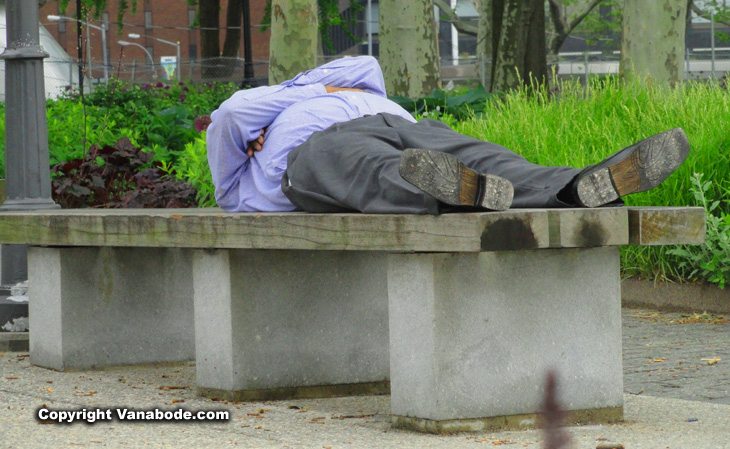 man sleeping on bench in new york city
